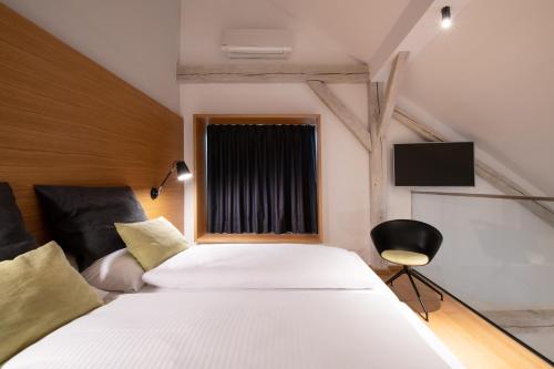 ミュンヘンにあるHotel Thalmairのベッドルーム(大きな白いベッド1台、窓付)