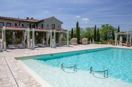 a swimming pool in front of a house at Relais Sassa al Sole in San Miniato