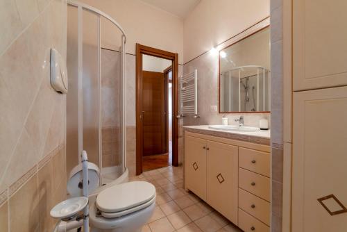 ein Badezimmer mit einem WC, einem Waschbecken und einem Spiegel in der Unterkunft Metro Cipro! Alle spalle del Vaticano Apartment x4 in Rom