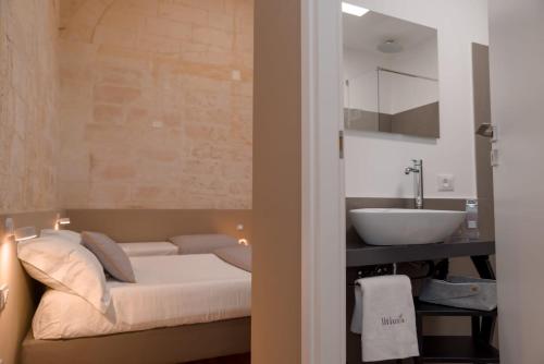 ein Bad mit einem Bett und einem Waschbecken in einem Zimmer in der Unterkunft Litium 3 in Lecce