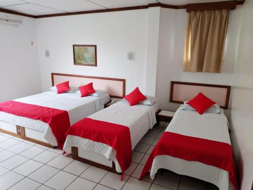 2 camas en una habitación con sábanas rojas y blancas en Hotel Portal De Eunápolis, en Eunápolis