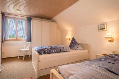 1 dormitorio con 2 camas y ventana en Ferienhof Wetzel Fewo 2, en Hergensweiler