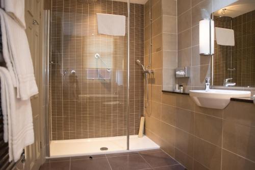 a bathroom with a glass shower and a sink at Crown & Mitre Hotel in Carlisle