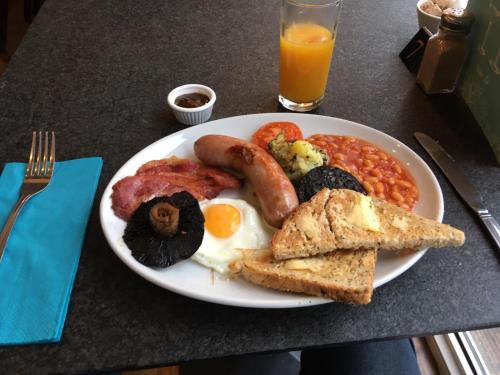 a plate of breakfast food with sausage eggs beans and toast at Sids restaurant and bar with rooms in Cardiff