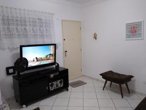 uma sala de estar com uma televisão de ecrã plano num suporte em Apto no Bairro do Gonzaga em Santos