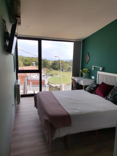 a bedroom with a large bed and a large window at Carrioza Alojamiento Turístico in Parada del Sil