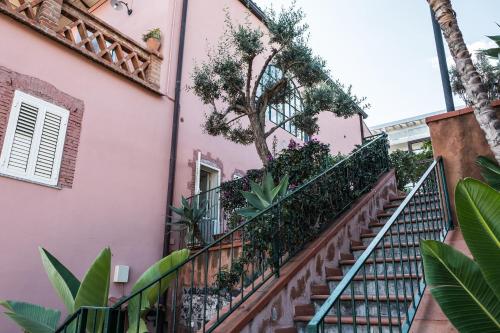 a staircase in a pink building with plants at Hotel Villino Gallodoro in Taormina