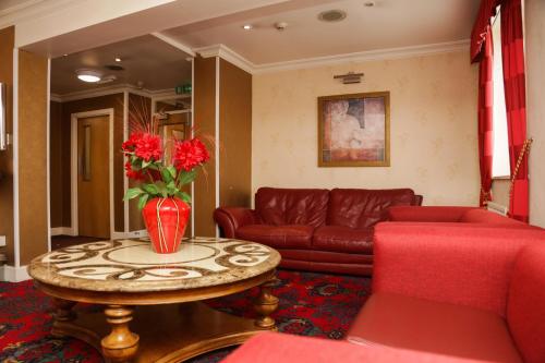 a living room with a couch and a table with red furniture at DJ Suites The Element in Manchester
