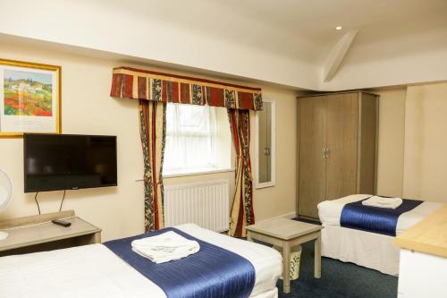 a hotel room with two beds and a flat screen tv at DJ Suites The Element in Manchester
