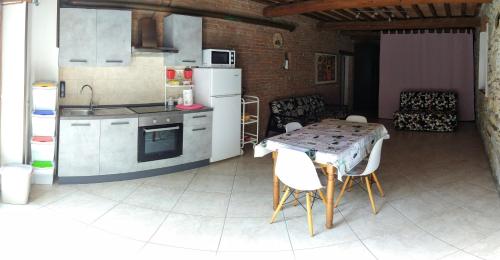 eine Küche mit einem Tisch, einem Tisch und Stühlen in der Unterkunft Casa Vanessa in Suvereto