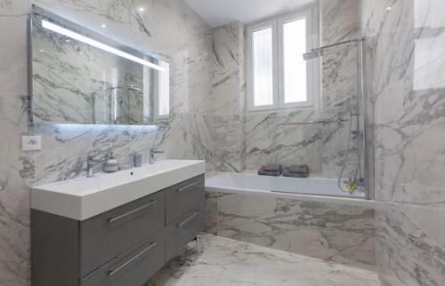 ein Badezimmer mit einem Waschbecken, einer Dusche und einer Badewanne in der Unterkunft Vieux-Port - Magnifique Appartement in Marseille