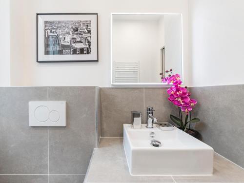 a bathroom with a white sink and a mirror at LivinParis - Luxury 3 Bedrooms Arc de Triomphe I in Paris