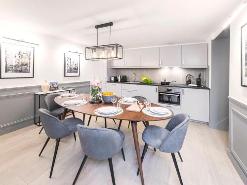 une cuisine et une salle à manger avec une table et des chaises dans l'établissement LivinParis - Luxury 3 Bedrooms Arc de Triomphe I, à Paris