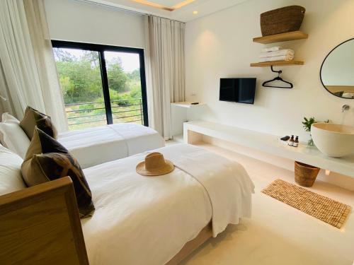 a bedroom with two beds with a hat on the bed at Barrington's in Plettenberg Bay