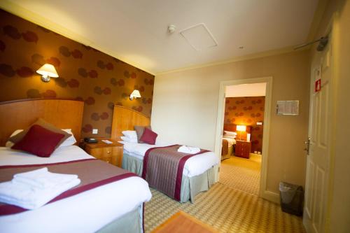 um quarto de hotel com duas camas e um corredor em Crown & Mitre Hotel em Carlisle