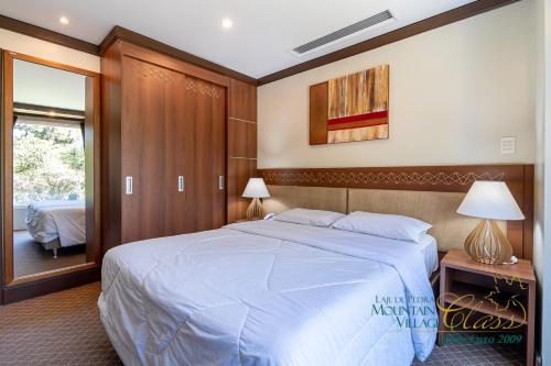 Un dormitorio con una cama grande y una ventana en Suíte Mountain Village, en Canela