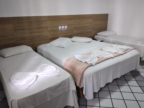 un grupo de 3 camas en una habitación en Arraial do Sol Beach Hotel, en Arraial d'Ajuda
