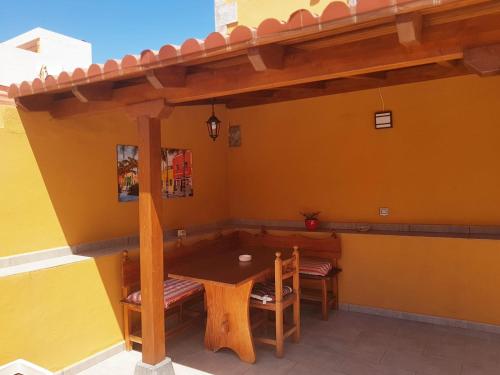 a table and chairs in a room with a yellow wall at Estudio nuevo con baño, cocina y gran terraza in Los Realejos