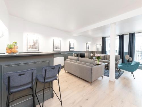 un salon avec un canapé, une table et des chaises dans l'établissement LivinParis - Luxury 4 Bedrooms Le Marais I, à Paris