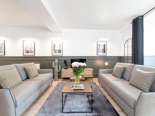 un salon avec deux canapés et une table dans l'établissement LivinParis - Luxury 4 Bedrooms Le Marais I, à Paris