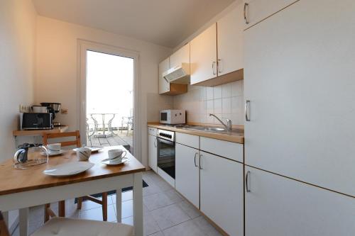 a kitchen with white cabinets and a wooden counter top at Fürstenhof Apartment Wismar in Wismar