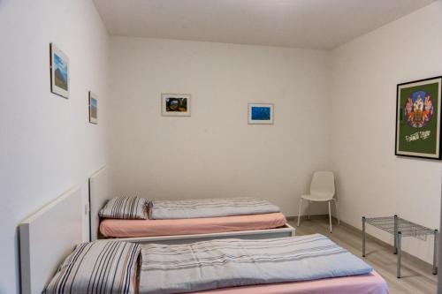 two beds in a room with a table and a chair at Casa vacanza FIUME in Pietramurata