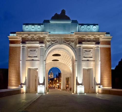 an arch at night with lights on at Novotel Ieper Centrum in Ypres