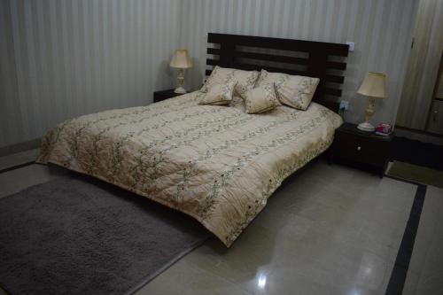 a bedroom with a large bed with two night stands at Holiday home On The rocks in Murree