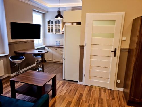 een woonkamer met een tafel en een keuken bij APART LuX BRISTOL in Bytom