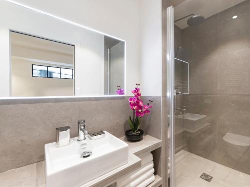 une salle de bain avec un lavabo, un miroir et une douche dans l'établissement LivinParis - Luxury 3 Bedrooms Le Marais III, à Paris
