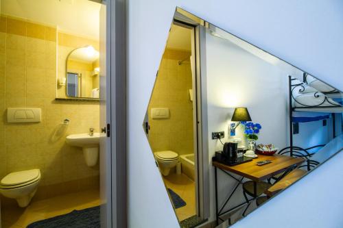 ein Badezimmer mit einem Waschbecken, einem WC und einem Tisch in der Unterkunft In Riva Al Lago in Como