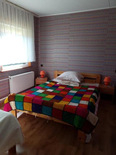 a bedroom with a colorful quilt on a bed at Kāpas in Jūrkalne