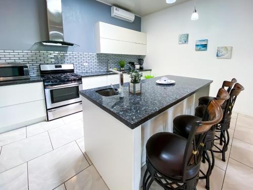 a kitchen with a counter with stools in it at Hotel Cabinas el Tecal in Uvita