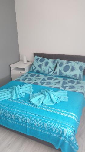 Una cama azul con una manta azul. en Apartments Kamenjar en Novi Sad