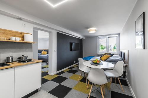 a kitchen and a living room with a table and chairs at Apartamenty Medyka Park in Medyka