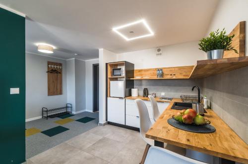 a kitchen with a table with a plate of fruit on it at Apartamenty Medyka Park in Medyka