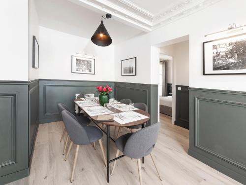 une salle à manger avec une table et des chaises dans l'établissement LivinParis - Luxury 3 Bedrooms Le Louvre II, à Paris