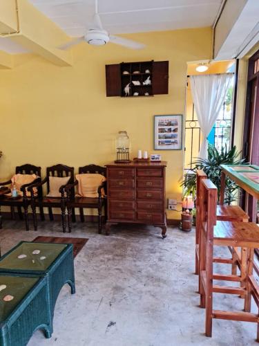 a living room with yellow walls and a wooden dresser at Klai Hat Inn in Hua Hin