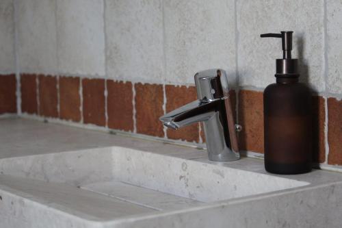 a bathroom sink with a soap dispenser next to it at Eleonora’s Home in Aosta