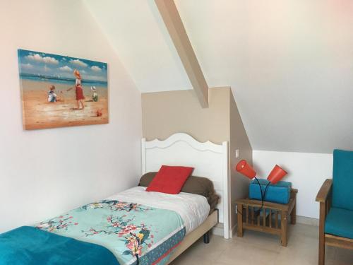 1 dormitorio con 1 cama y una pintura en la pared en Gites Bellevue, en Beauvoir