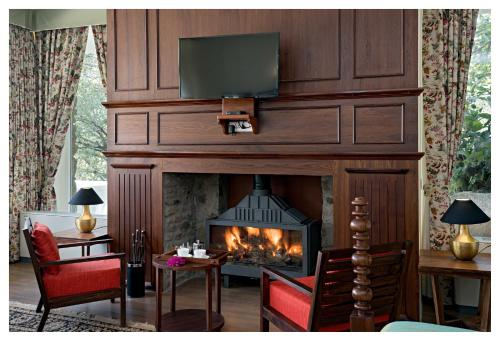 a living room with a fireplace with a tv above it at Wordsworth Lodge in Mount Ābu