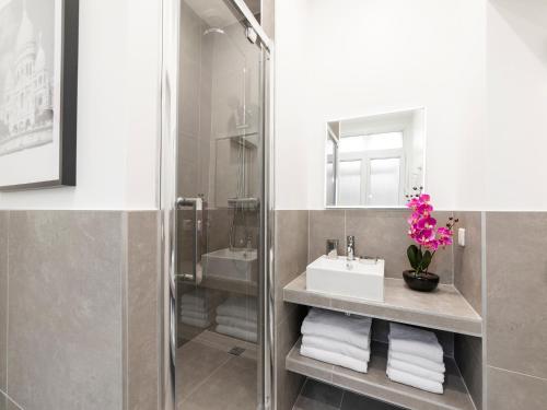 une salle de bain avec un lavabo et un miroir dans l'établissement LivinParis - Luxury 3 Bedrooms Opera I, à Paris