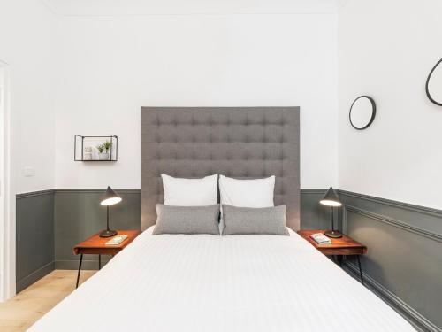 1 dormitorio con 1 cama grande y 2 lámparas en LivinParis - Luxury 3 Bedrooms Opera I, en París