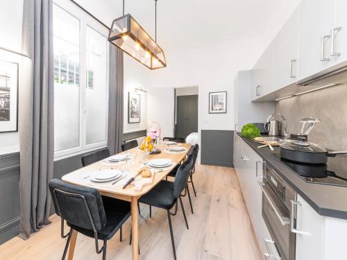 une salle à manger avec une table et des chaises dans une cuisine dans l'établissement LivinParis - Luxury 3 Bedrooms Opera I, à Paris