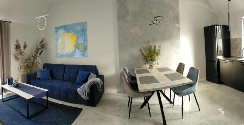 een woonkamer met een blauwe bank en een tafel bij Apartament - Come in in Lubin