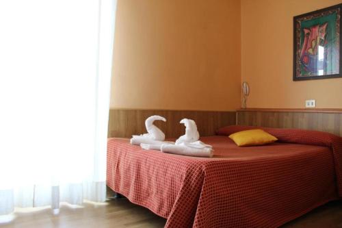 two swans sitting on top of a bed at Hotel Lugano in Milan