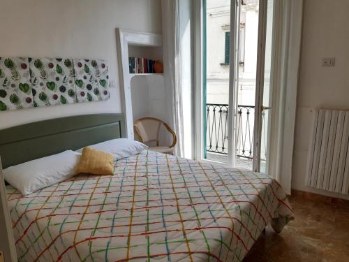 ein Schlafzimmer mit einem Bett mit einer bunten Decke und einem Fenster in der Unterkunft Casa Sebastian A in Vietri