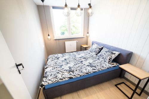 a small bedroom with a bed and a window at Apartament Piano Centrum in Racibórz