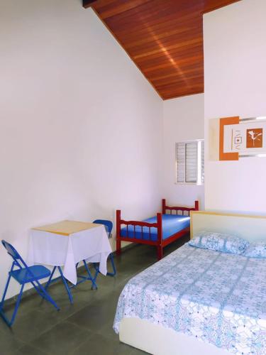 a bedroom with a bed and a table and chairs at Recanto da Nina in Maresias