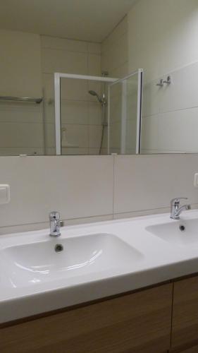 a bathroom with two sinks and a large mirror at Cityhostel Wieselburg in Wieselburg